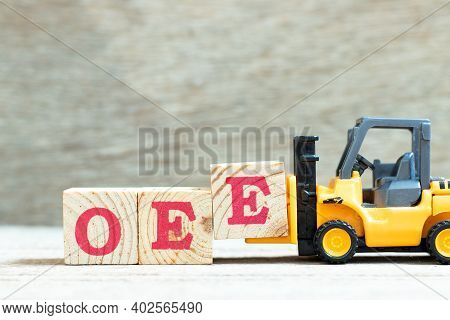 Toy Forklift Hold Letter Block E To Complete Word Oee (abbreviation Of Overall Equipment Effectivene