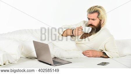 Screen Time And Insomnia. Happy Hipster Drink Coffee In Bed. Bearded Man Enjoy Coffee And Surfing In