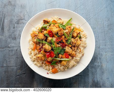 Vegetarian Meat Free Mycoprotein Pieces Vegetable Stir Fry, Brown Rice Served In White Plate