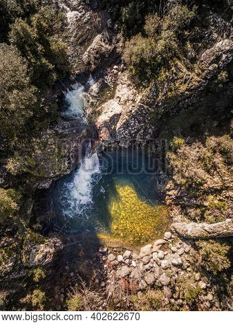 Mountain Stream Cascading Into A Rocky Pool In Corsica