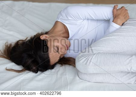 Close Up Unhappy Woman Suffering From Bellyache, Lying On Bed