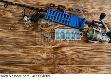 Flat Lay With Fishing Tackle, Fishing Rod And Plastic Box With Fishing Tackle And Hooks, Feeders On