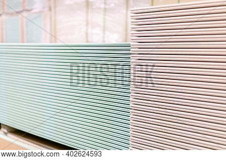 Pallet With Drywall Sheets Plasterboard In The Building Warehouse Store. Stacking Of White Gypsum Pa