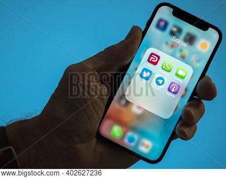 Morgantown, Wv - 9 January 2021: Male Hand With Iphone And Parler And Twitter Apps To Illustrate Dis