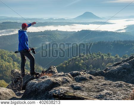 Man Photographer Looking With Camera In Hands For Subject Bellow Mountain Path. Active Traveler With