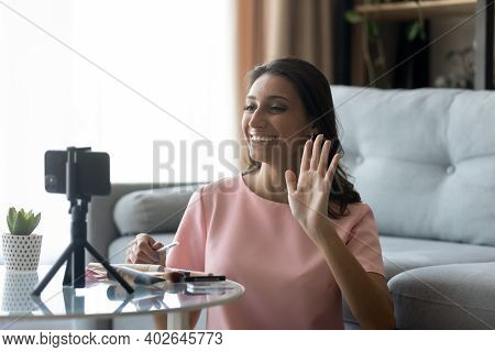 Smiling Ethnic Woman Blogger Shoot Cosmetics Haul On Cellphone