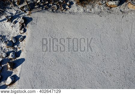 Snowy Parking From Above. Large Stones Delimit The Parking Space. A Barrier Made Of Giant Tribes Tha