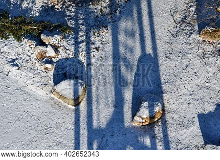 Snowy Parking From Above. Large Stones Delimit The Parking Space. A Barrier Made Of Giant Tribes Tha