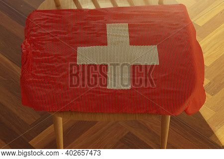 3d Rendering Of Wolly Swiss Flag Covering The Wooden Chair And Laminate