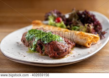 Pork Neck With Chickpea Roll And Salad Mix. Restaurant Main Course With Well Done Meat, Veal Or Beef