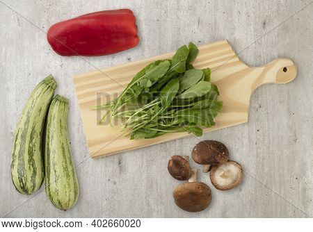 Vegetables, Mushrooms And Salad Ingredients Over Wooden Table.