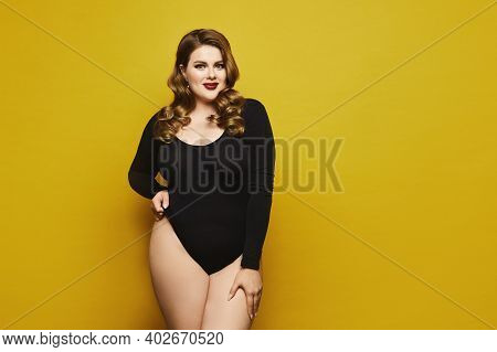 Beautiful Plus-size Model Woman With Bright Makeup In Black Bodysuit Posing Over Yellow Background, 