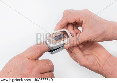 The Hand Of An Elderly Man Inserted A Finger Into The Pulse Oximeter In The Hands Of An Elderly Woma