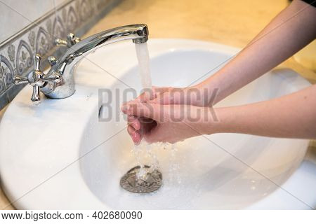 Teenager. Washing Hands In The Bathroom Sink. Frequent Hand Washing Is A Prerequisite For Good Hygie