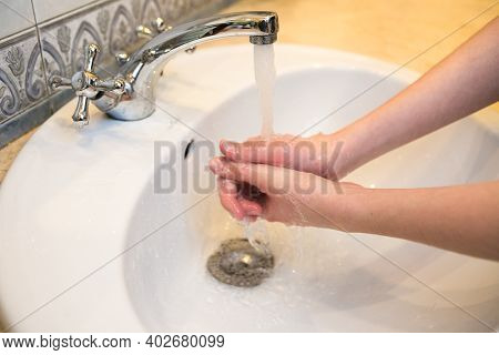 Teenager. Washing Hands In The Bathroom Sink. Frequent Hand Washing Is A Prerequisite For Good Hygie