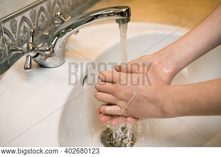 Teenager. Washing Hands In The Bathroom Sink. Frequent Hand Washing Is A Prerequisite For Good Hygie
