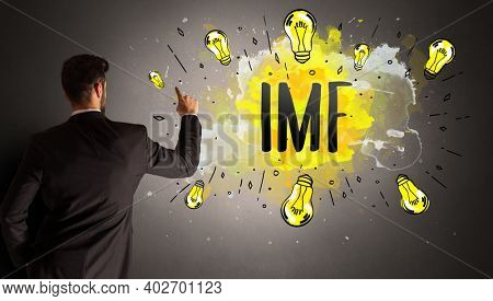 businessman drawing colorful light bulb with IMF abbreviation, new technology idea concept