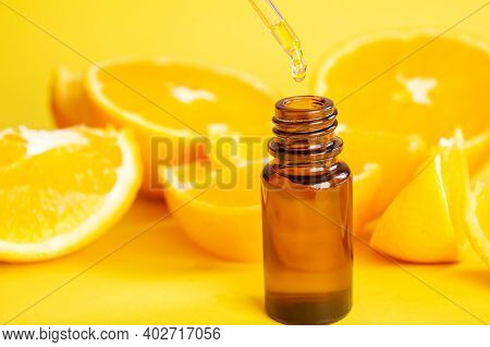 Orange Essential Oil On A Yellow Background. Selective Focus.