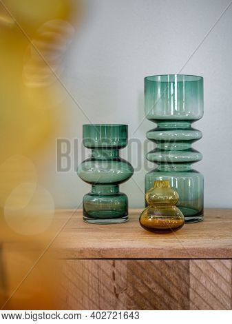 Empty Decorative Vases From Transparent Glass On Wooden Cupboard With Blured Foreground. Interior De