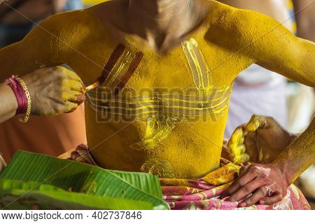 Theyyam artist preparing to perform during temple festival in Payyanur, Kerala, India. Theyyam is a popular ritual form of worship in Kerala, India