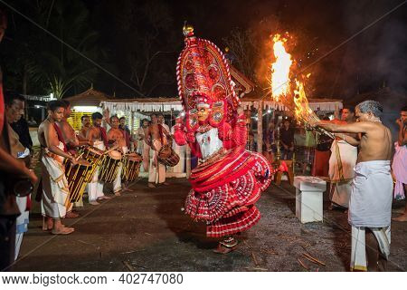 Payyanur, India - December 5, 2019: Theyyam artist perform with fire during temple festival in Payyanur, Kerala, India. Theyyam is a popular ritual form of worship in Kerala, India