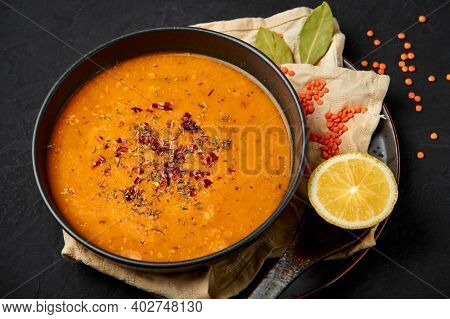 Ezogelin Soup In Black Bowl On Dark Slate Table Top. Turkish Cuisine Traditional Dish With Red Lenti