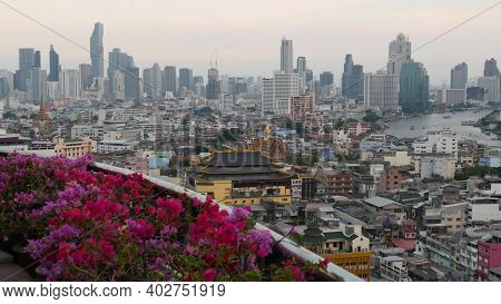 View Of Traditional And Modern Buildings Of Oriental City. Beautiful Flowerbed Against Cityscape Of 