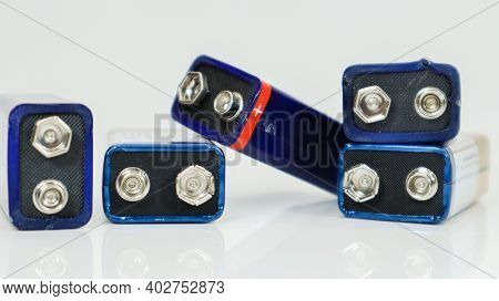 Five Blue Used, Chaotically Laid Out And Scattered Pp3 Batteries On A White Background With Reflecti