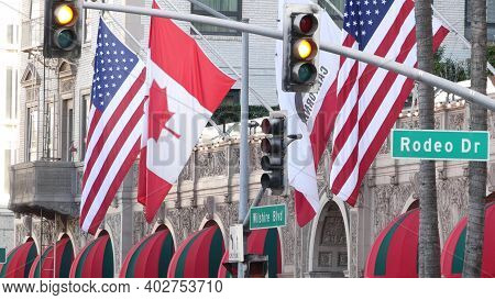 World Famous Rodeo Drive Street Road Sign In Beverly Hills Against American Unated States Flag. Los 