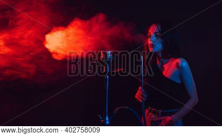 A Young Girl Enjoys Smoking A Hookah, Sheesha. Photo With Space For Text