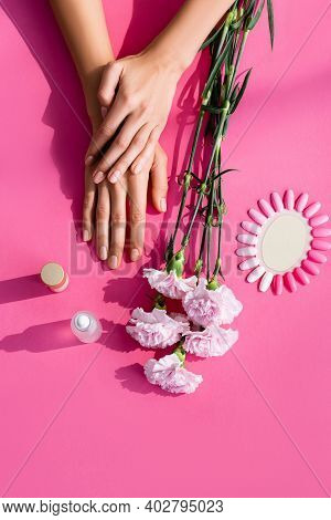 Top View Of Female Hands Near Carnation Flowers, Palette Of Artificial Nails, Cuticle Remover And Na