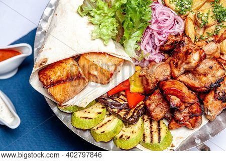 Mixed Grill Meat Fried Vegetables And Grilled Salmon Fish Fillets Decoration In Warm Dish. Assorted