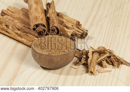 Cinnamon Powder And Cinnamon Stick; Photo On Wooden Background.