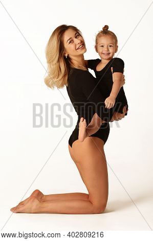 Cute Baby Girl And Mum In Black Bodies Having Fun Full Body Studio Portrait