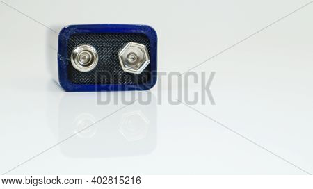 One Blue Used Pp3 Battery On A White Background With Reflection. Main Battery For Personal Power Sup