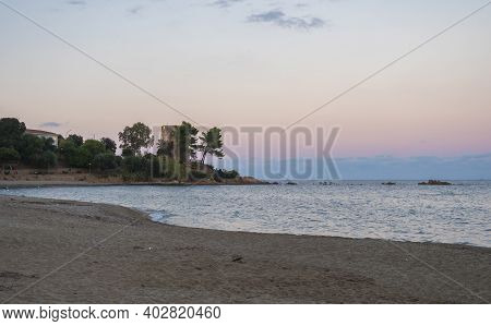 View Of Empty Spiaggia Di Santa Maria Navarrese Sand Beach With Green Trees And Old Stone Tower Torr