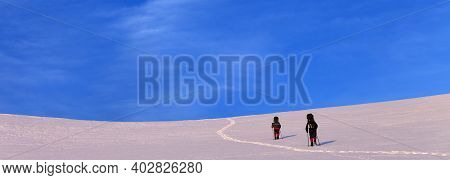 Two Hikers On Sunrise Snowy Plateau In High Mountains. Turkey, Central Taurus Mountains, Aladaglar (