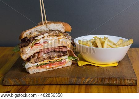 Doble Burger With Doble Cheddar Cheese, Lettuce, Bacon And French Fries.