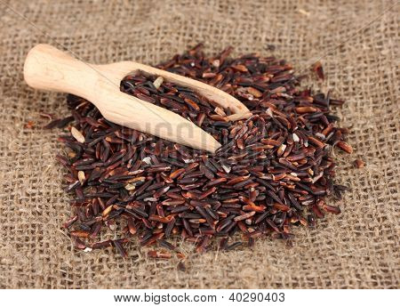 arroz preto com colher de madeira em esteira de bambu