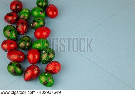 Multicolored Quail Eggs Green And Red On A Blue Background With Place For Text. Happy Easter Postcar