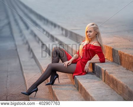 Beautiful Blonde Girl In Red Skirt With Perfect Legs In Pantyhose And Shoes With High Heels Posing O