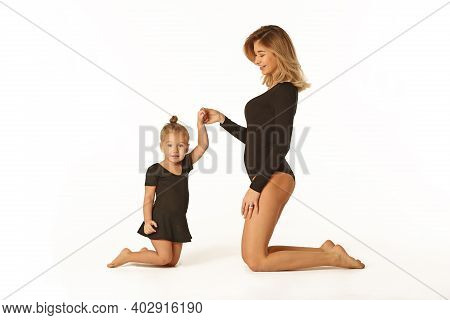 Cute Baby Girl And Mum In Black Bodies Having Fun Full Body Studio Portrait