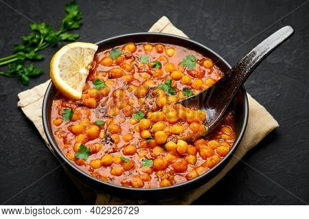 Chana Masala Or Chole In Black Bowl On Dark Slate Table Top. Indian Cuisine Veg Chickpeas Curry Dish