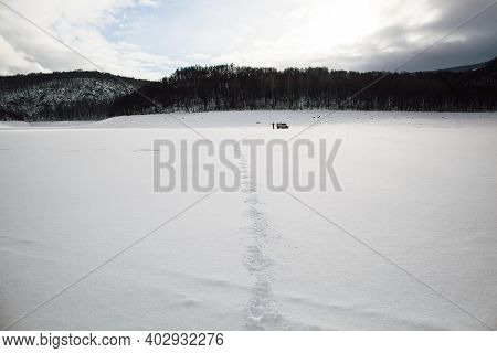 Tire Tracks In The Snow, Winter Road, Empty Road In Winter Goes Far To The Horizon, Covered With Sno
