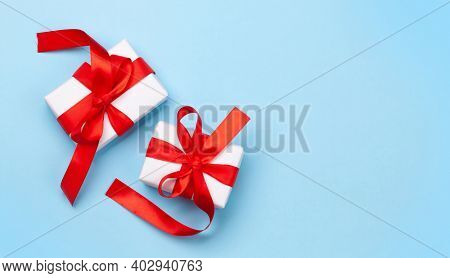Valentines day greeting card template. Gift boxes over blue background. Top view flat lay with copy space