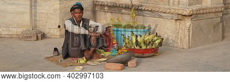 Old Man Selling Corn On The Counter In A Touristic Area. An Indian Street Vendor Selling Roasted Cor