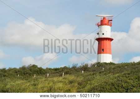 Red and white striped lighthouse at Borkum beach