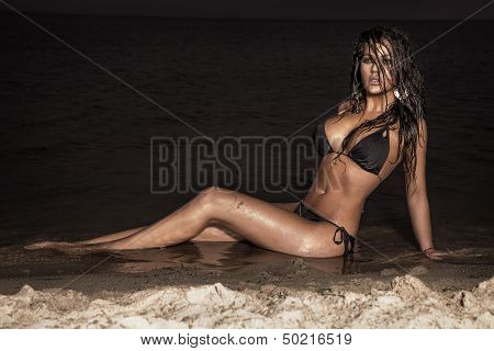 Attractive Brunette Lady Posing On The Beach At Night.