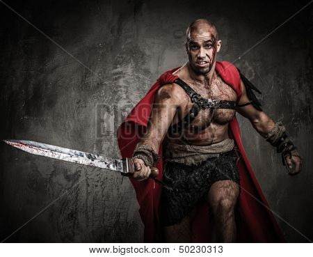 Wounded gladiator attacking with sword covered in blood 