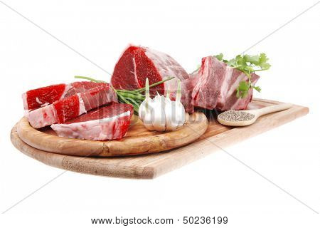 raw meat : fresh beef pork big rib and fillet with garlic and green stuff on wood isolated over white background